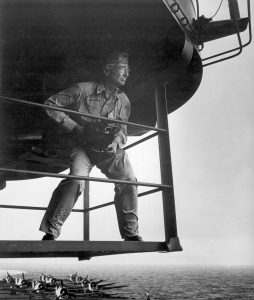 Edward J. Steichen, photographic expert, on island platform, studies his surrounding for one of his outstanding photographs of life aboard an aircraft carrier. Steichen held the rank of Comdr. at this time. Ca. Attributed to Lt. Victor Jorgensen. (Navy) Exact Date Shot Unknown NARA FILE #: 080-G-324556 WAR & CONFLICT #: 759